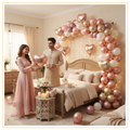 Luxury blush champagne anniversary bedroom decoration with organic balloon arch, Happy Anniversary foil balloons, red heart foil balloons and fairy lights.