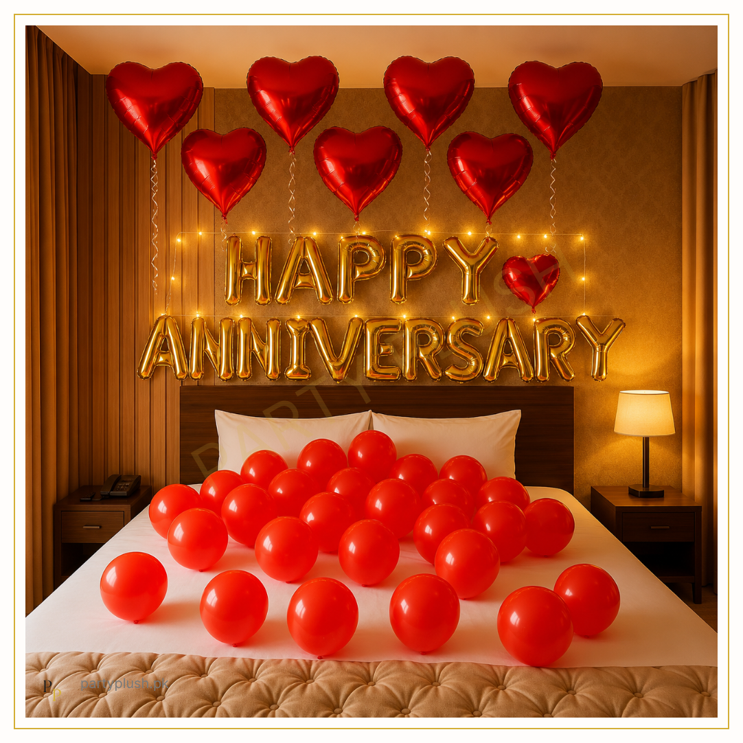 Happy Anniversary bedroom decoration with gold foil letters, red heart foil balloons and romantic balloon setup.