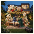 Luxury garden anniversary decoration with organic balloon arch, gold Happy Anniversary foil balloons, red heart foil balloons, fairy lights and romantic outdoor setup.