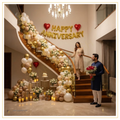 Luxury staircase anniversary decoration with elegant balloon garland, gold Happy Anniversary foil balloons, red heart foil balloons and warm fairy lights.