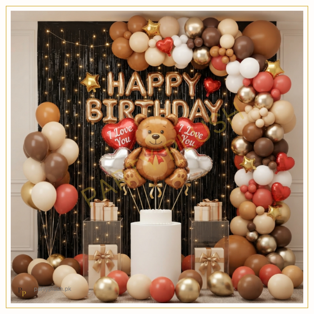 Teddy Bear birthday balloon decoration featuring teddy bear foil balloon, rose gold Happy Birthday foil letters, black fringe curtain, fairy lights, brown, nude and cream balloon garland with heart foil balloons.