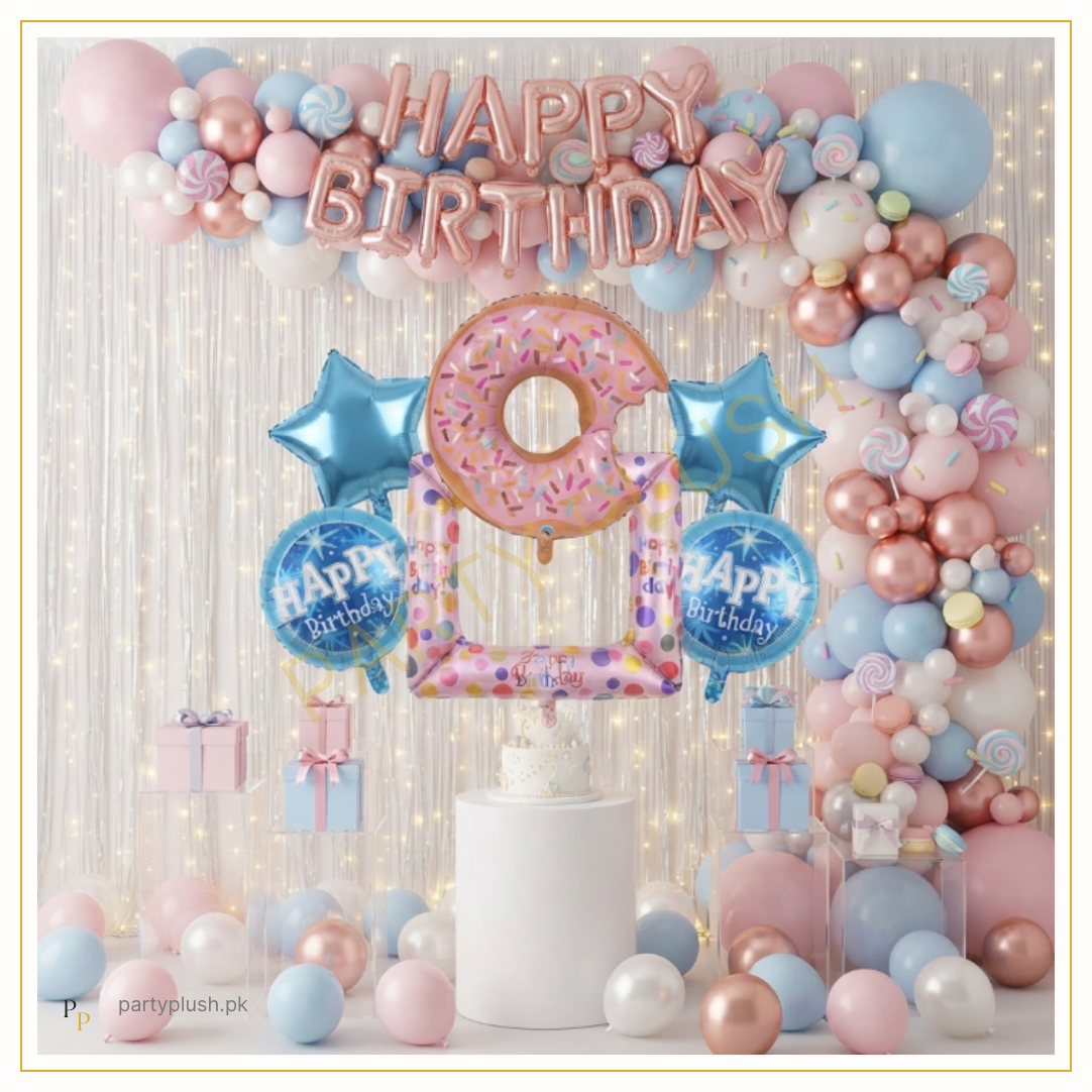 Pastel donut birthday decoration setup with rose gold Happy Birthday foil balloons, pastel pink and blue balloon arch, donut foil balloon, candy balloons and birthday backdrop.