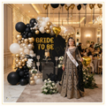 Royal Black Luxe Bride decoration with black, white and gold balloon arch, gold Bride To Be foil letters, gold heart foil balloons and luxury bridal shower setup.