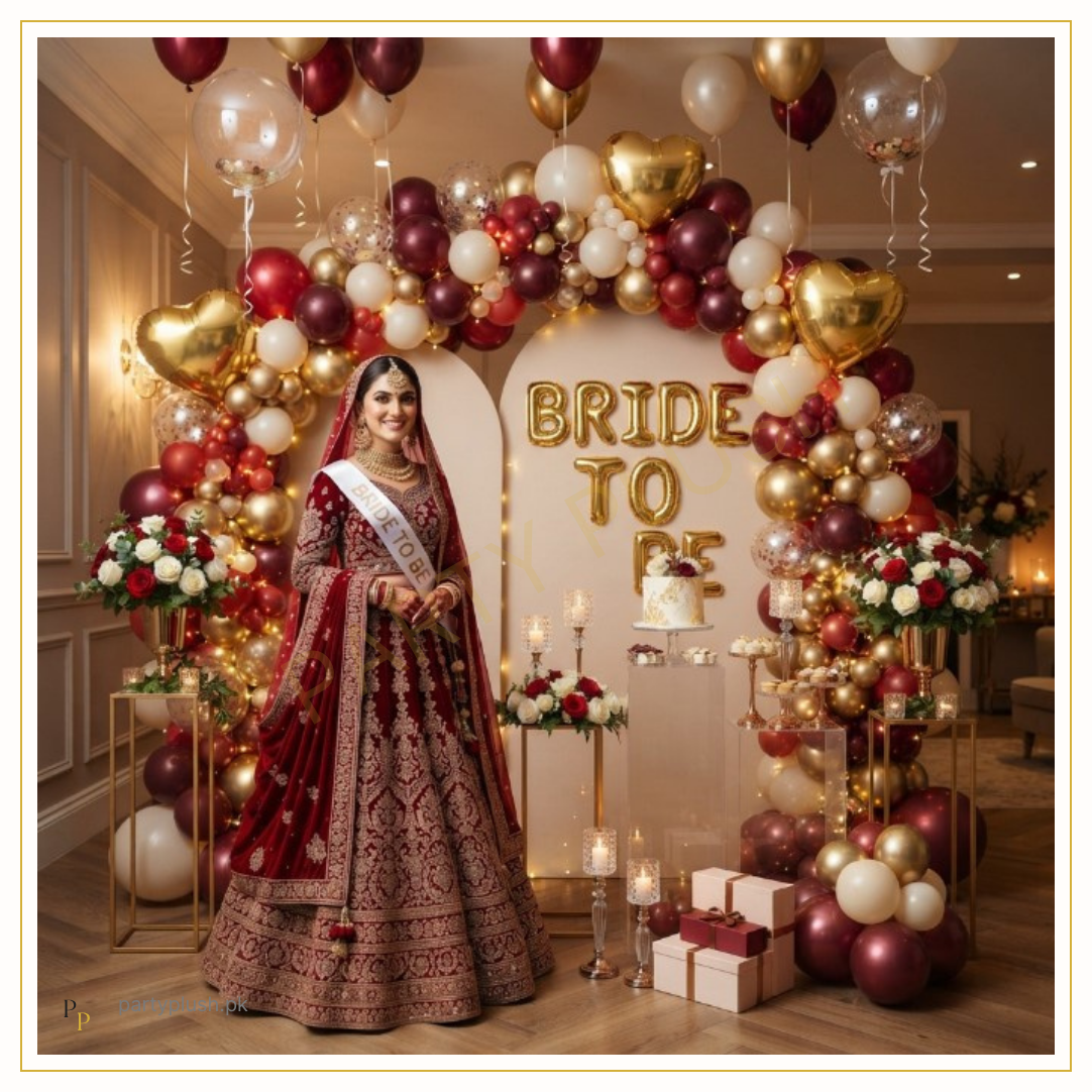 Ruby Velvet Bride decoration with burgundy, red, gold and ivory balloon arch, gold Bride To Be foil letters, gold heart balloons and luxury bridal shower décor.